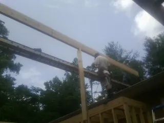Carpenter setting a ridge beam over a new addition frame — Ice Dam Removal by Roofing Brothers in Bridgeton